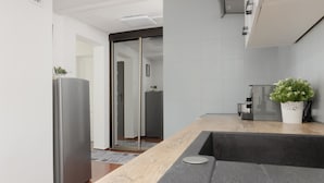A modern kitchen with a stainless steel refrigerator, a wooden countertop, and a potted plant. - Spacious Apartment in Zoliborz | Terrace | Workspace (Warszawa)