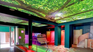 A spa area with a hot tub, stairs, and a ceiling with a tree design.