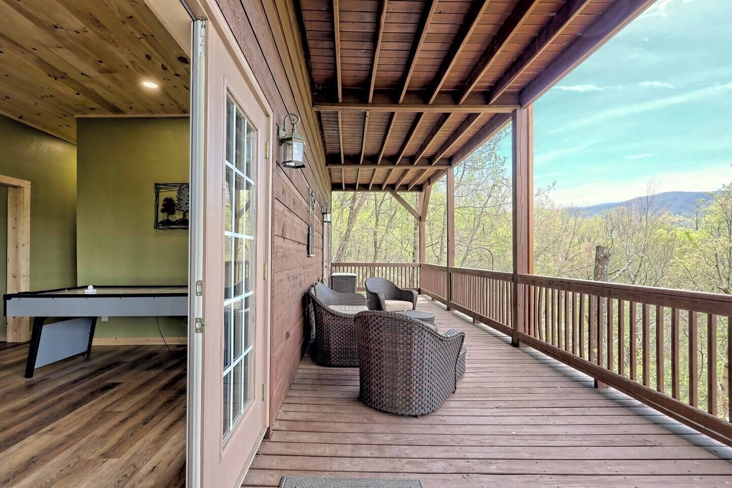 A wooden deck with outdoor seating and a pool table.