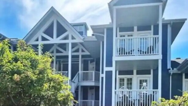 Un hilero de casas de dos pisos con barandillas blancas y fachada azul.