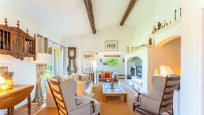 Un salon spacieux doté d’une cheminée, de meubles en bois et offrant une vue sur l’extérieur.