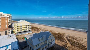 Una proprietà sulla spiaggia con una grande casa, un edificio più piccolo e un albergo.