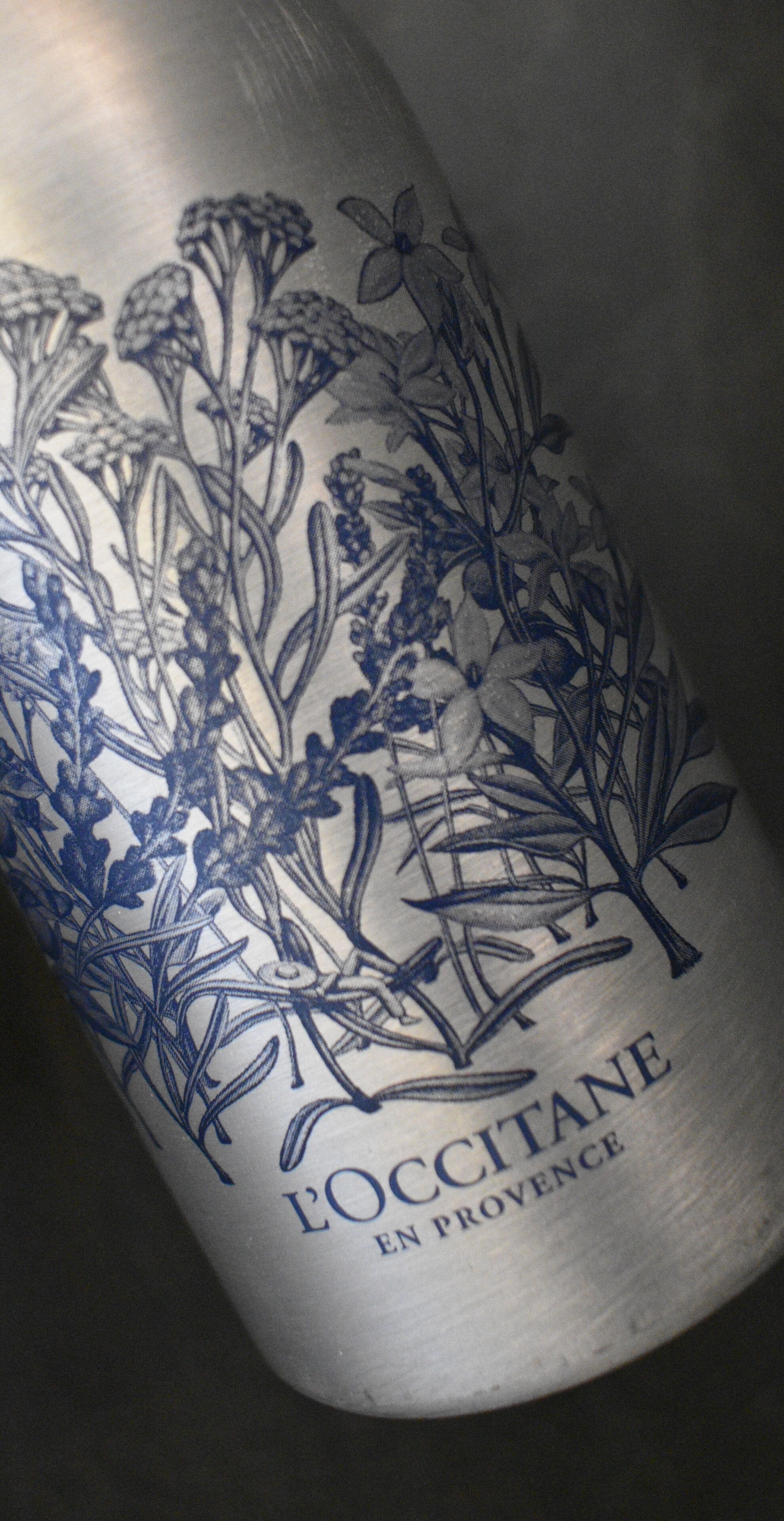 Een fles met een blauw bloemendessin en de tekst 'POCCITANE EN PROVENCE'.
