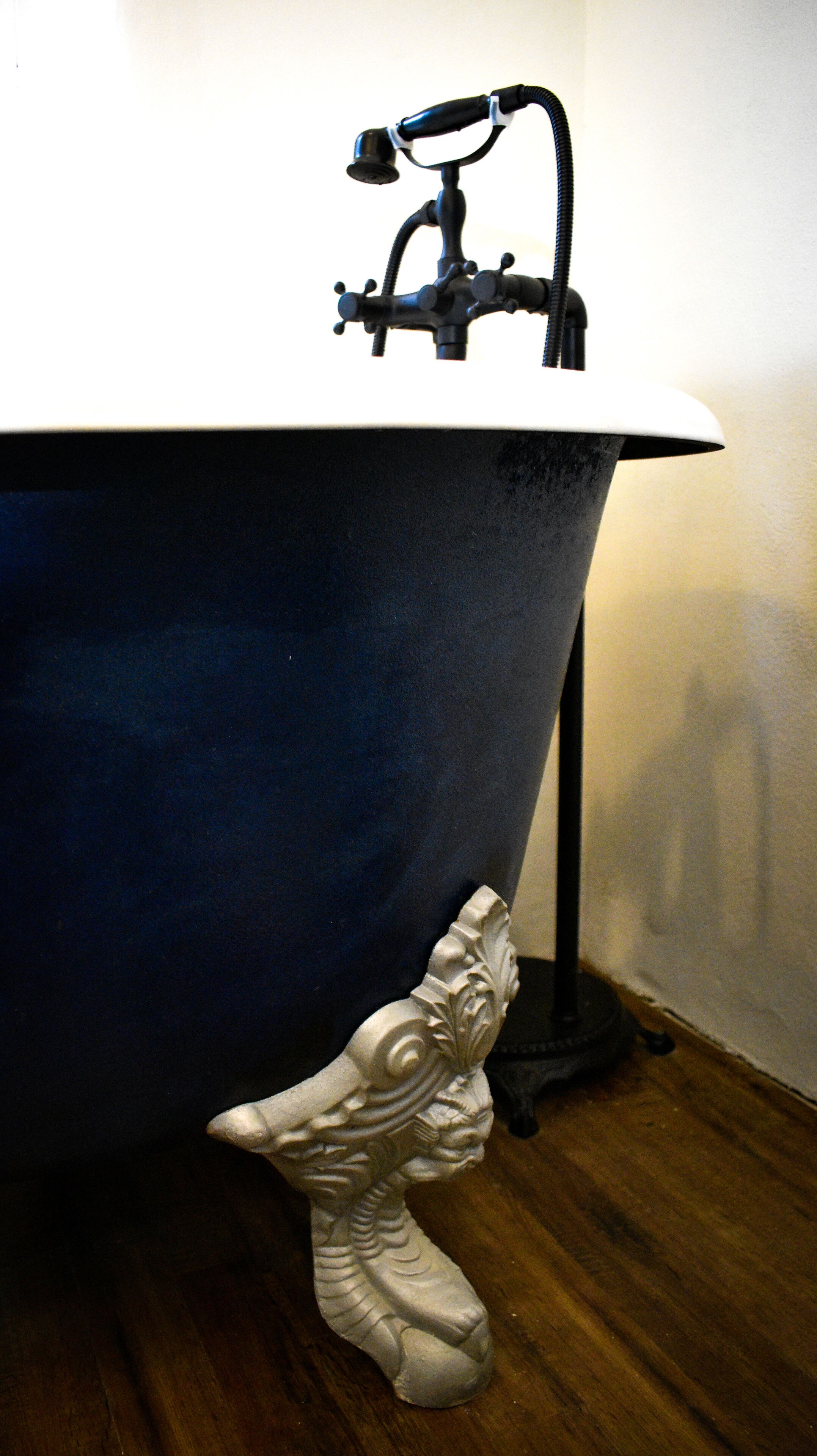 A bathtub with a faucet and a decorative figure.