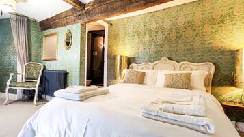 A bedroom with a large bed, a chair, and a radiator.
