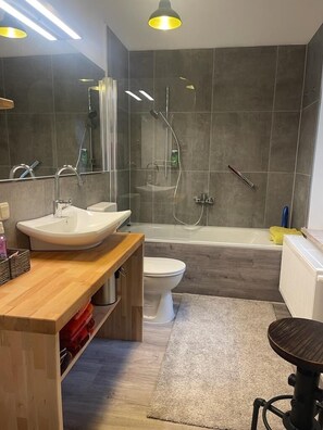 Bathtub, hair dryer, towels, shampoo