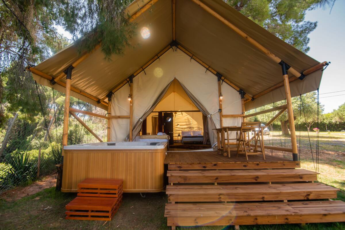 Une tente dotée d’une terrasse en bois et d’un bain à remous.