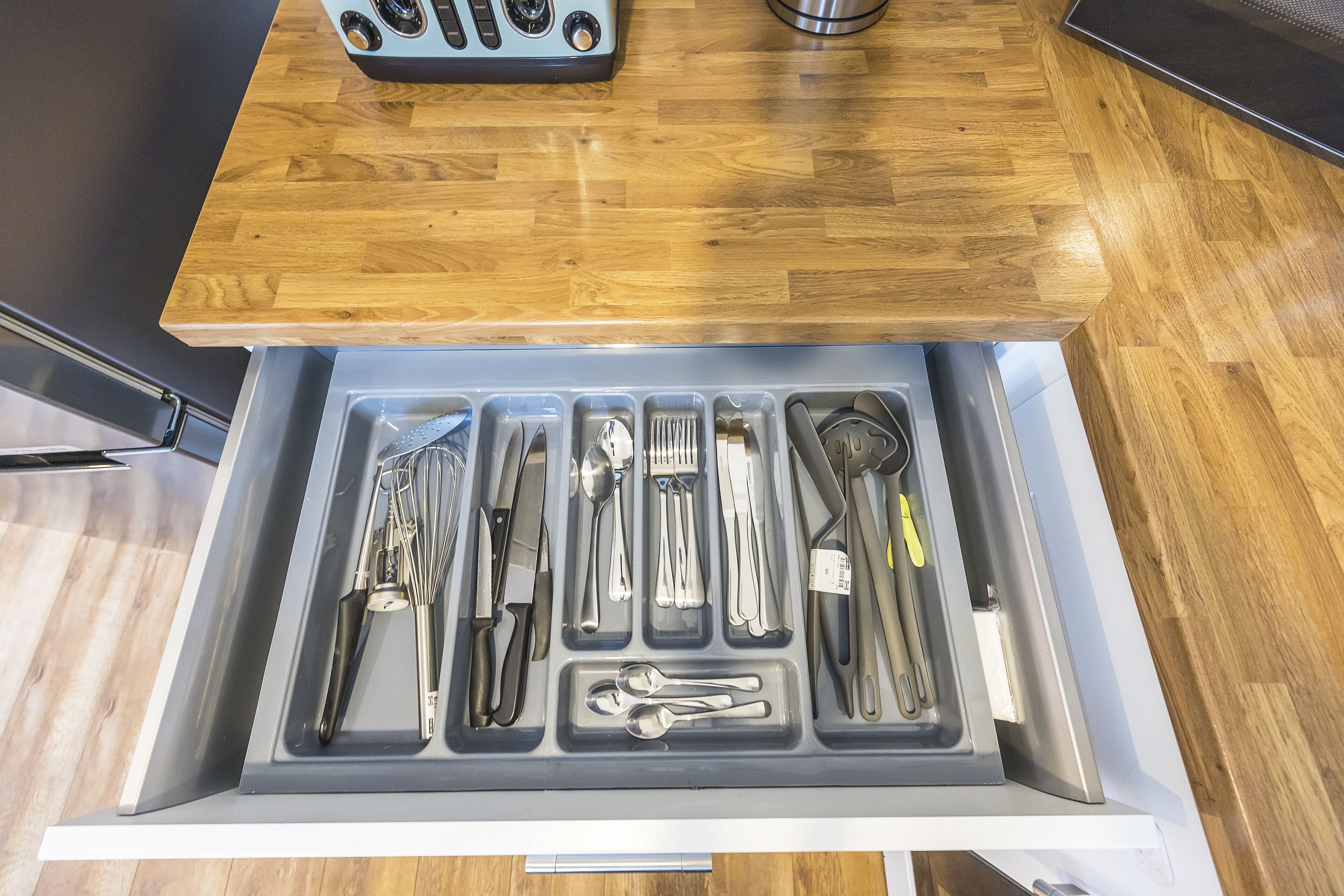 A drawer with utensils neatly organized in compartments.