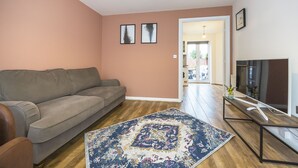 A living room with a sofa, a coffee table, a TV, and a patterned rug. - The Lake Hub (Dagenham)
