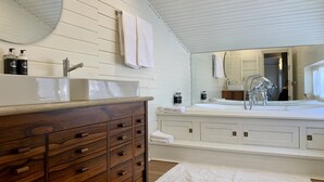 A bathroom with a wooden vanity, a large mirror, and a bathtub. - Cerrado das Fontainhas (Sintra)