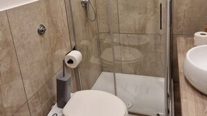 A bathroom with a glass-enclosed shower, a toilet, a bidet, and a sink. - Tribunali Platamon (Naples)