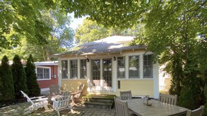 Une maison dotée d’un patio couvert, d’un espace salon extérieur et d’un petit jardin.