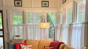 Un salon chaleureux avec un canapé d’angle, une petite table ronde et un lampadaire.
