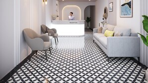 Un espace d’accueil au design moderne, comprenant un comptoir d’accueil, un coin salon et un sol à motifs.