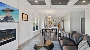 A modern living room with a fireplace, a dining area, and a kitchen in the background. - DerbyGrove: Newly Renovated & Near Derby (Jeffersonville)