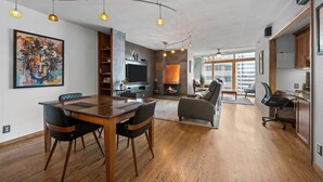 A modern interior with a dining area, fireplace, and large windows. - Condo in the Sky - Amazing Views - Gym (denver)