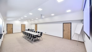 A conference room with a long table, chairs, a whiteboard, and a projector. - Sport Rooms Spała (Inowlodz)