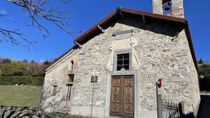 En gotisk kirke med et klokketårn, en trædør og et skilt, der angiver, at det er en turistattraktion.