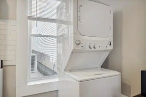 Laundry room with washer and dryer, offering a view of the outside through a large window.