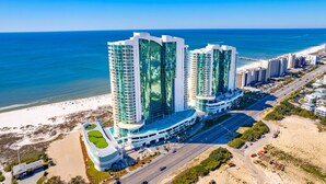 Un hôtel de grande hauteur au design moderne, situé près d’une plage et offrant une vue dégagée sur l’océan.