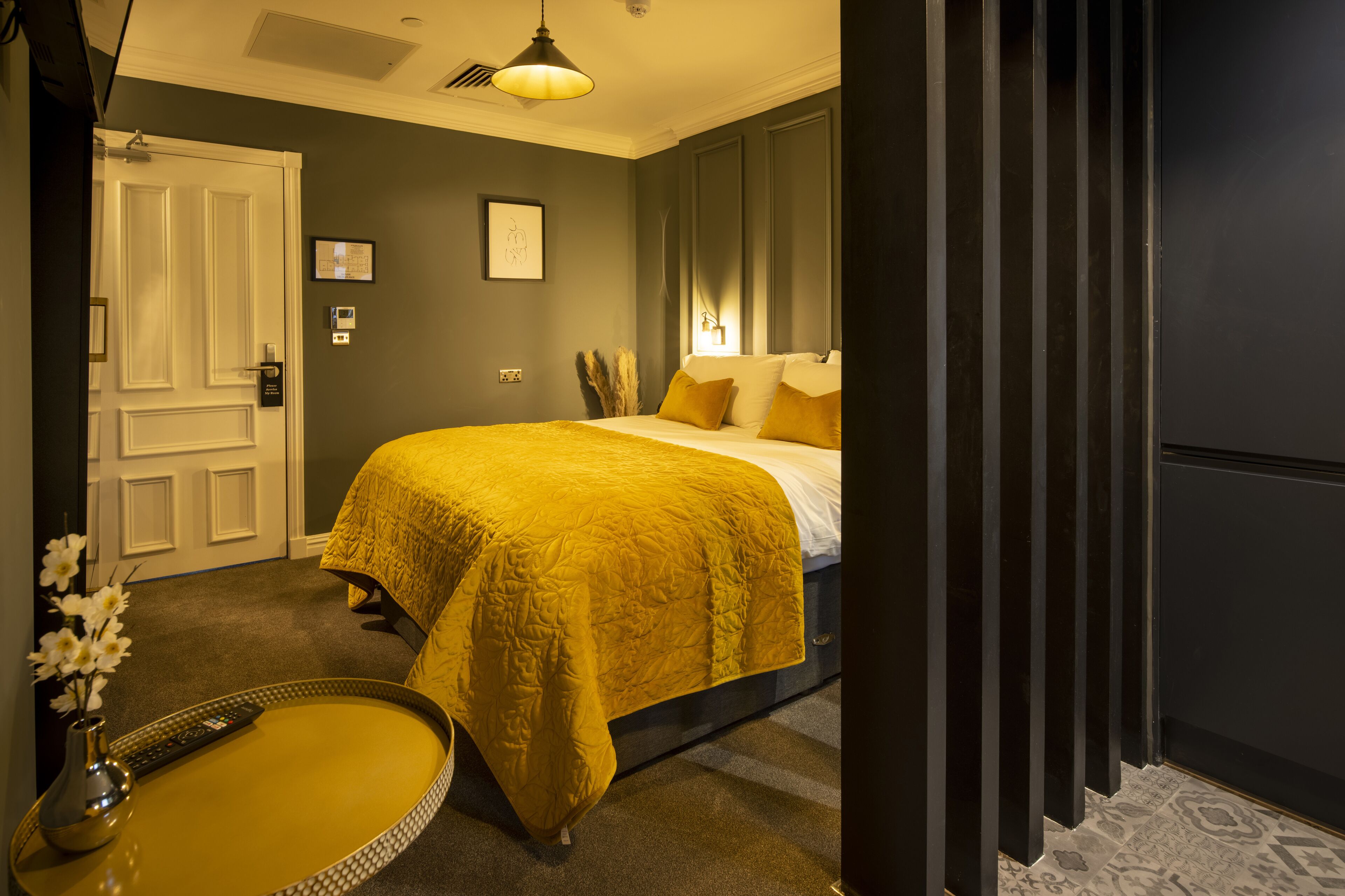 A bedroom with a bed, bedside table, and a door.