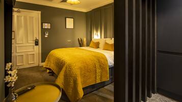 A bedroom with a bed, bedside table, and a door.