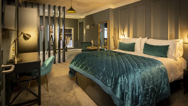 Ein Schlafzimmer mit einem großen Bett, einem Schreibtisch und einem Stuhl.