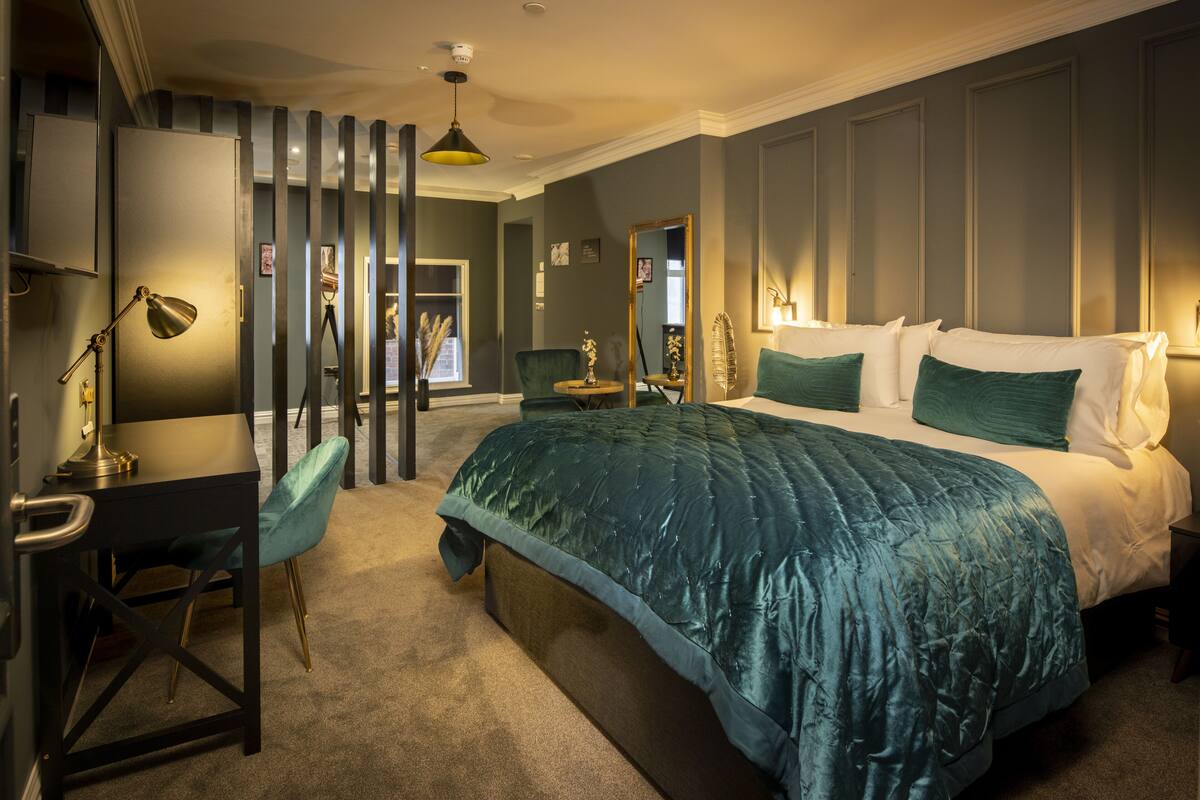 Une chambre avec un grand lit, un bureau et une chaise.