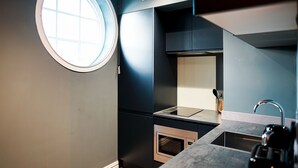 Eine moderne Küche mit Einbauofen, Spüle und Fenster.
