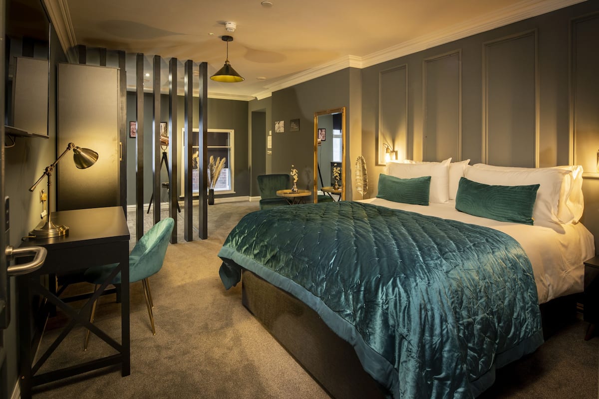 Une chambre avec un grand lit, un bureau et une chaise.