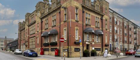 A historic building with multiple stories, large windows, and a prominent corner entrance.