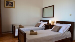 A hotel room with two single beds, wooden headboards, a nightstand with a lamp, and a framed picture on the wall. - Villa Julio spacious  first floor apartment  with a great terrace (Seget Donji)
