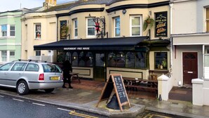A corner building with a black awning labeled "The Independent Free House," featuring a signboard for "Best Noted Ales Served by Stark Brewing Co." - Station Lodge By My Getaways (Brighton)
