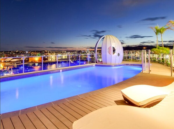 Relax by the rectangular pool surrounded by a deck, featuring a unique water feature.