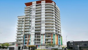 A multi-story hotel with balconies, a covered entrance, and a modern architectural design. - Light apartment in amazing central location (South Brisbane)