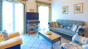 A living room with a sofa, a coffee table, a TV, and a bookshelf. - Theophilos 2 in (Corfu)