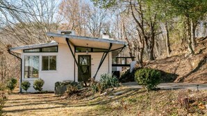 Ein modernes Einfamilienhaus mit geneigtem Dach, großen Fenstern und einer Veranda.