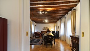 A dining area with a wooden table and chairs, a patterned rug, and a chandelier. - Luxury apartment, 100m from Piazza San Marco, Venice (Venezia)