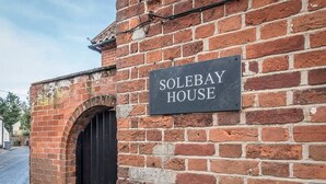 A brick building with a black door and a sign that reads "SOLEBAY HOUSE". - Solebay House, Tunstall (Woodbridge)