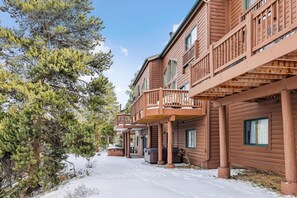 Cozy log cabins with balconies offer a view of the surrounding landscape.