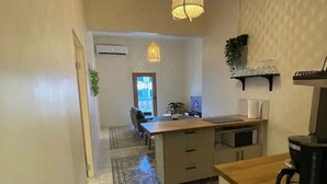 Una cocina moderna con una isla central, una cafetera y una lámpara colgante.