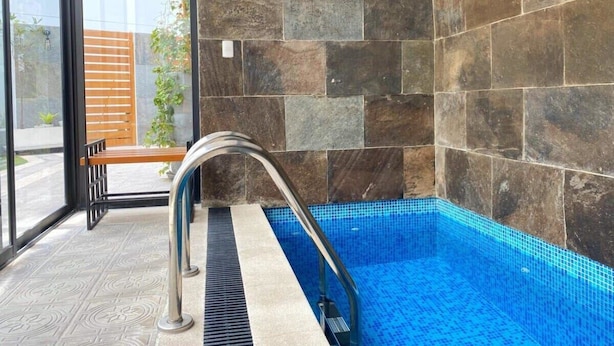 A modern indoor swimming pool with stone walls and a metal pool ladder. - w* | 1BR near Central Restaurant in Barranco (Barranco)