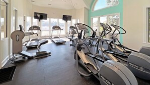 A gym with treadmills, ellipticals, and a stationary bike. - Salty Sunsets: Hot Tub | 2 Kitchens | Pool Access (Corolla)