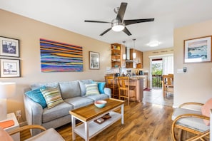 A living room with a grey sofa, wooden coffee table, and a ceiling fan.