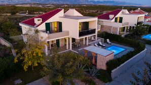 A modern two-story house with a swimming pool, outdoor seating, and a view of the mountains. - Villa Dana with Private Pool (Novalja)