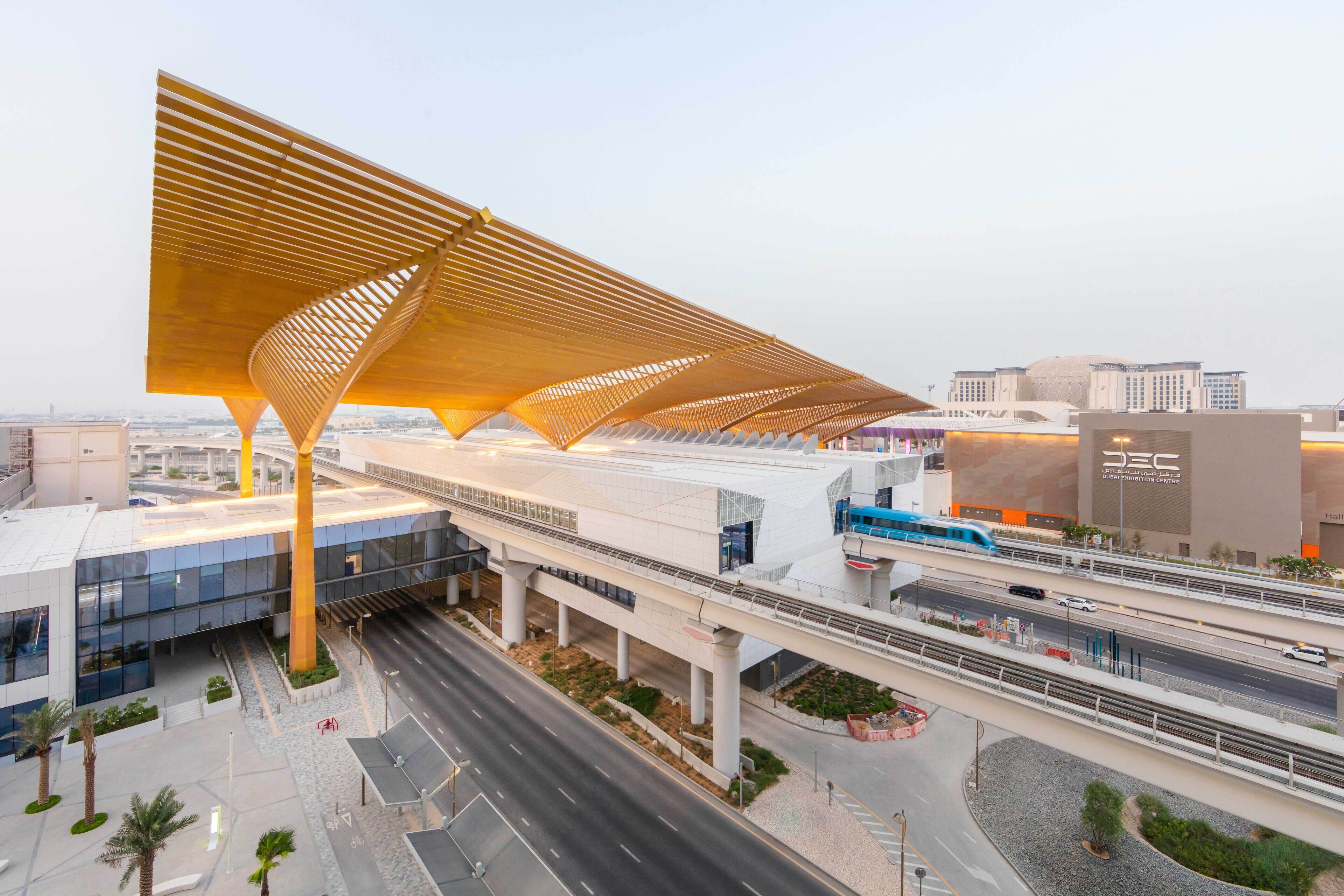 A modern architectural structure with a prominent wooden canopy and multiple levels of walkways.