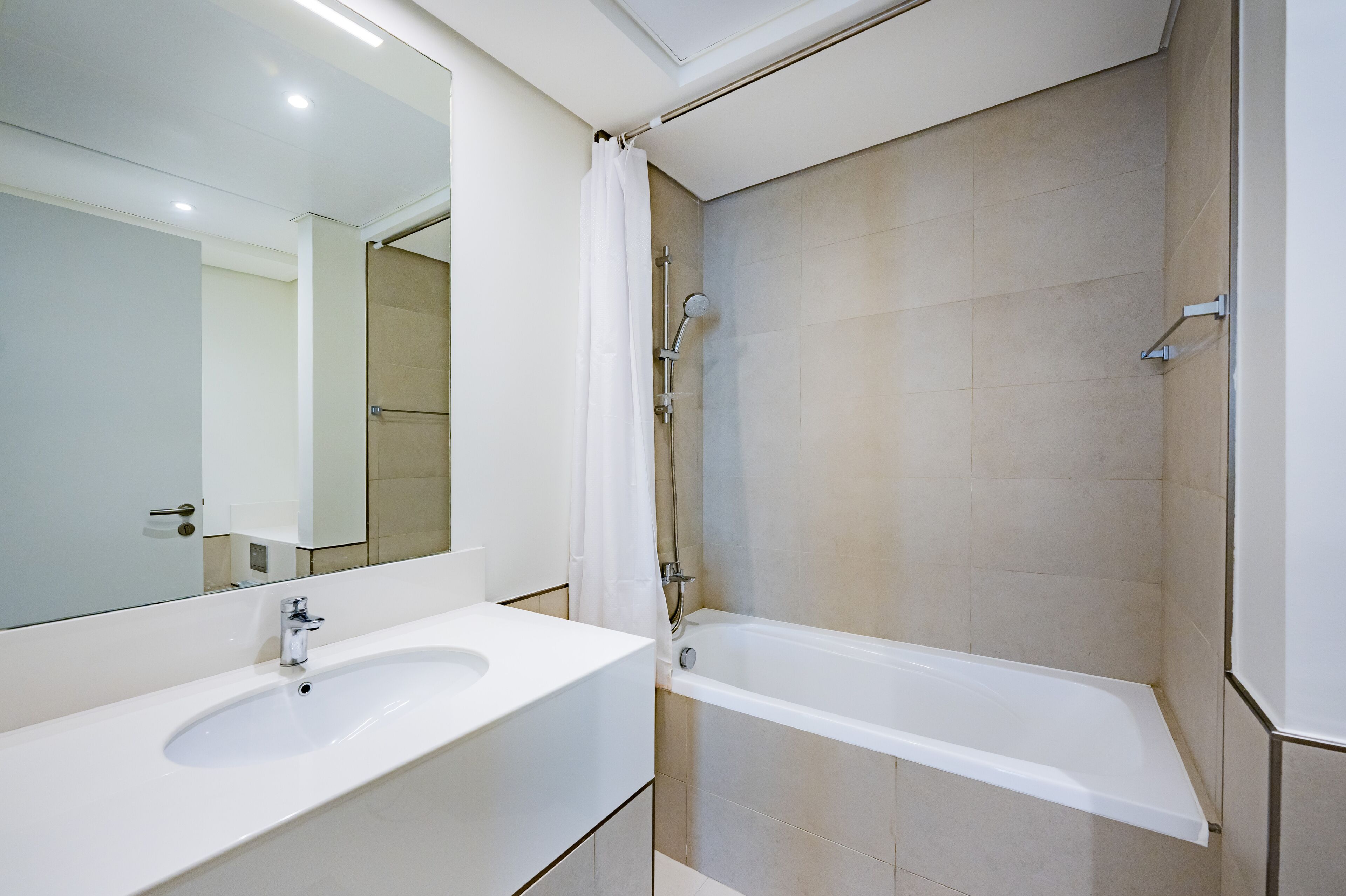 Uma casa de banho moderna com uma sanita branca, uma banheira e um chuveiro.
