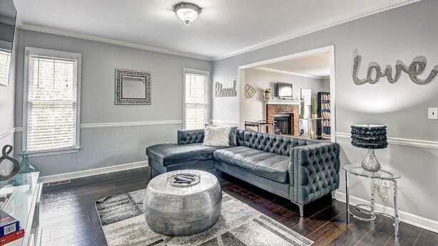 A spacious living room with a sectional sofa, a fireplace, and a large mirror on the wall. - Stone Mountain  Home  Amazing Yard & Pool (Stone Mountain)