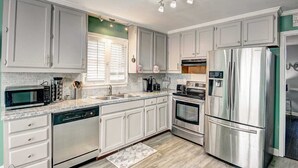 A modern kitchen with white cabinets, stainless steel appliances, and a granite countertop. - Stone Mountain  Home  Amazing Yard & Pool (Stone Mountain)