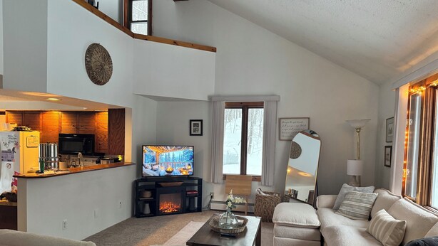 A spacious living room with a fireplace, a television, and a cozy seating area.